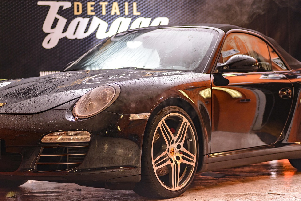 Professional automotive detailing workshop with technician performing specialized service on luxury vehicle